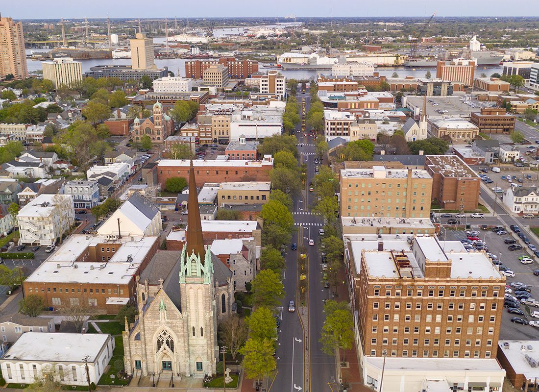 Contact - Aerial View of a Town With Many Buildings and Trees Along Roads